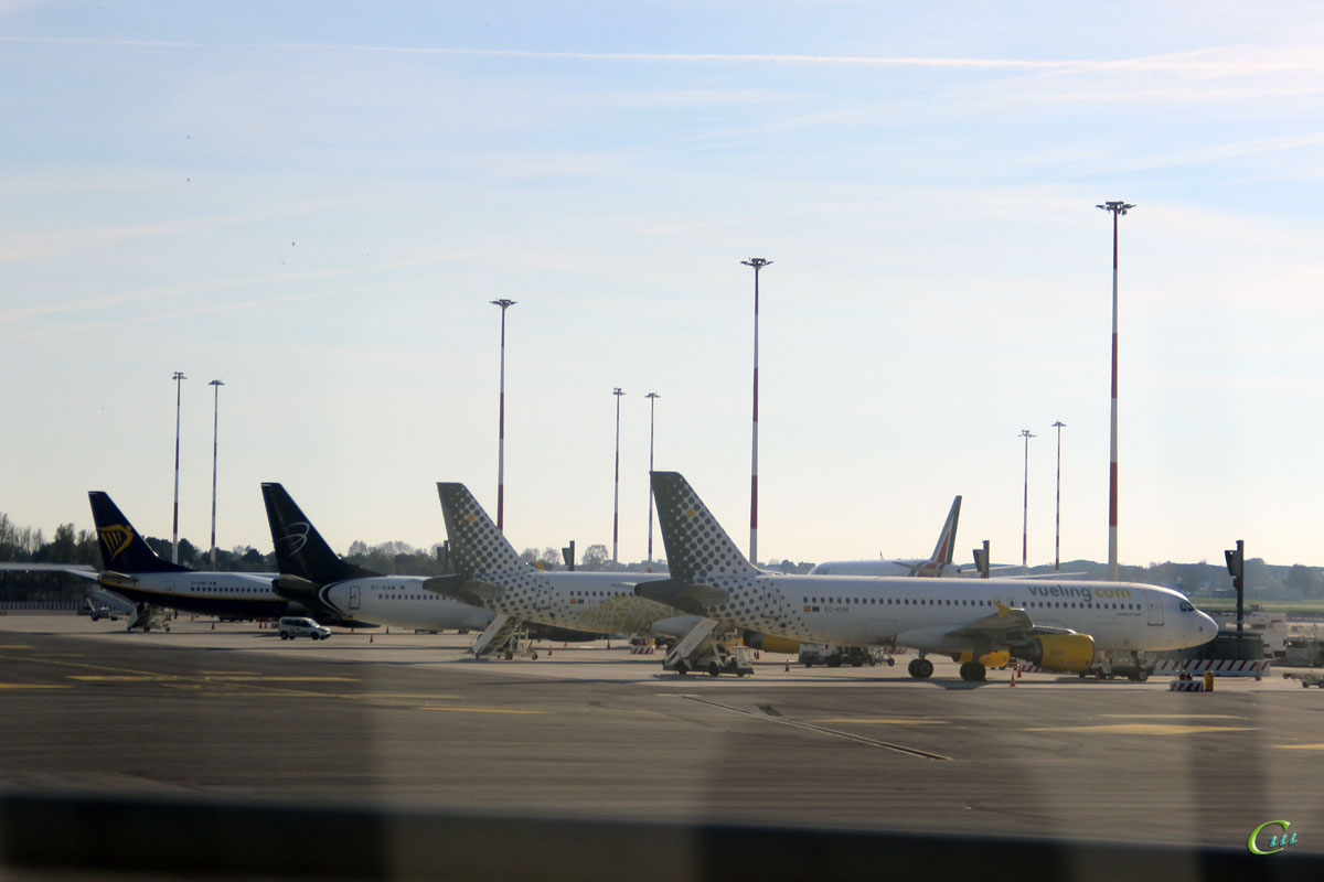 Рим. Самолеты (справа налево) Airbus A320 (EC-KHN) авиакомпании Vueling, Airbus A320 (EC-MNZ) авиакомпании Vueling, Boeing 737 (EI-EBR) авиакомпании Blue Panorama и Boeing 737 (EI-ENS) авиакомпании Ryanair